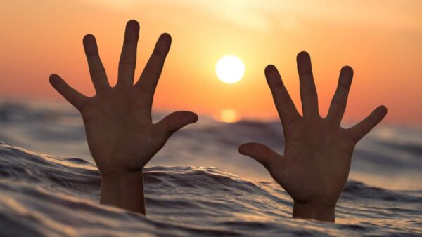 hands-protruding-water-in-sunset
